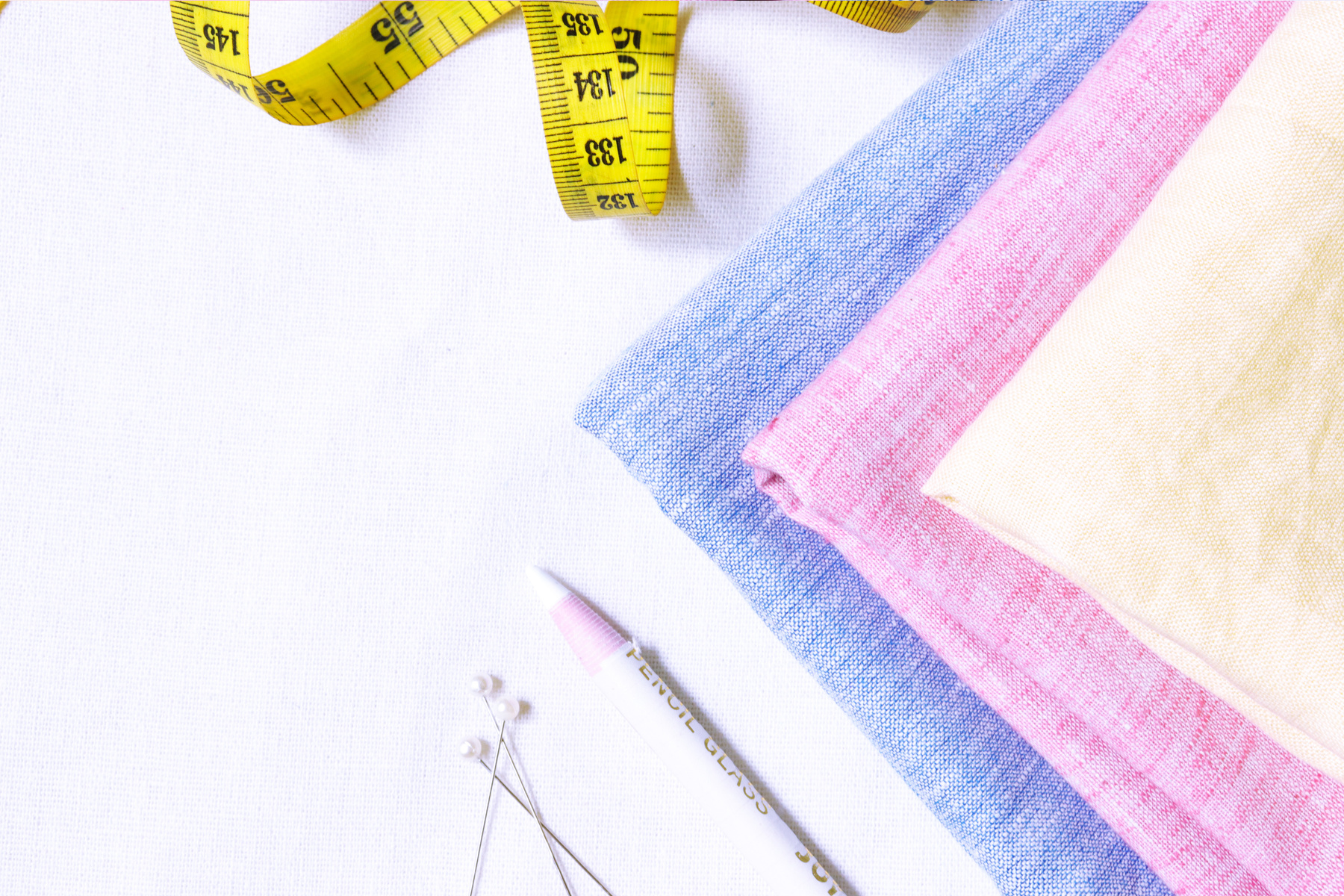 Yellow Measuring Tape Beside Purple and Pink Textile